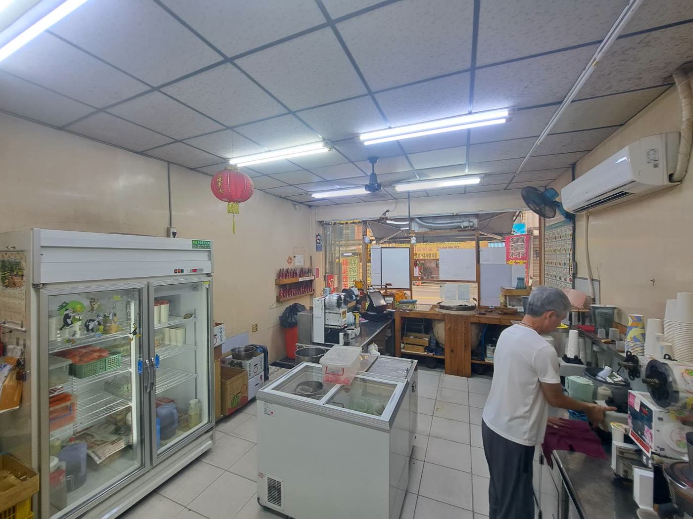 老闆在店裡的工作台前準備飲料